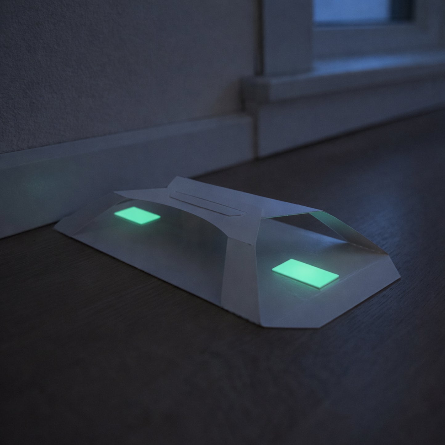 Larder beetle trap with photoluminescent attractor glowing at night